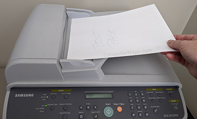 Inserting paper into a scanner feeder.