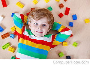 Child laying with lego bricks.