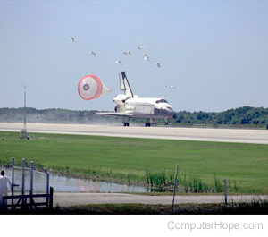 Space shuttle landing on a runway.