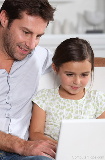 Father over shoulder of girl on computer