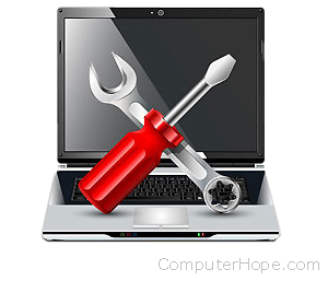 Screwdriver and wrench over a laptop.