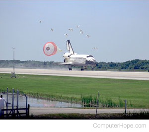 Space shuttle landing on a runway.